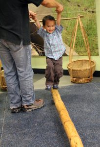 A child balances on a bamboo bridge, part of the Voyage to Vietnam exhibit. Courtesy The Children’s Discovery Museum of San Jose.