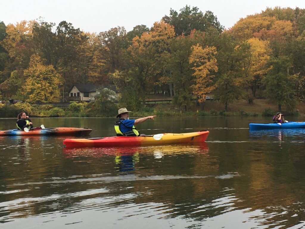 Three kayaks skim the lake at North Park to look at fall foilage.